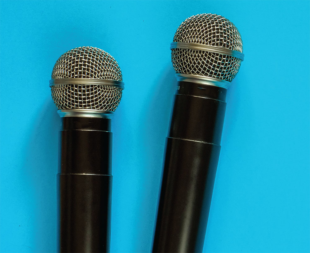 Photo of two microphones against a blue background
